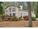 Inviting two-story home features a spacious wooden deck, enhancing outdoor living, surrounded by lovely trees and greenery at 5296 Golfcrest Cir, Stone Mountain, GA 30088