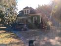 Charming two-story home with green siding, latticework details and a car parked nearby at 109 Smith St, Locust Grove, GA 30248