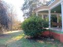 Inviting covered porch with a swing, offering a relaxing outdoor space surrounded by nature at 109 Smith St, Locust Grove, GA 30248