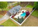 Aerial view of home with a beautiful pool, outdoor fireplace and well-maintained yard at 155 Duncans Mill Dr, Locust Grove, GA 30248