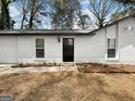 Inviting front entrance with a black screen door and neutral landscape at 2800 Chelsey Trl, Jonesboro, GA 30236