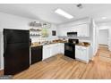Bright kitchen with white cabinets, black appliances, and wood-look countertops at 2800 Chelsey Trl, Jonesboro, GA 30236