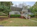 View of a house featuring a well-maintained lawn and verdant shrubs at 6140 Ginn Se St, Covington, GA 30014
