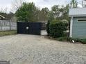 Gravel driveway with fenced perimeter, offering privacy and security at 6121 N Main Se St, Acworth, GA 30101