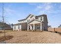 Charming two-story home with neutral siding, a covered porch, and a neatly kept lawn on a sunny day at 315 Arwen Dr # 105, Mcdonough, GA 30252