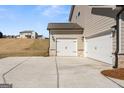 Spacious three-car garage with white doors and stone detailing, complemented by a concrete driveway at 315 Arwen Dr # 105, Mcdonough, GA 30252