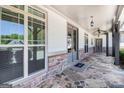 Inviting covered porch with stone flooring, ceiling fans, and elegant entry doors at 1 Red Oak Trl, Sharpsburg, GA 30277