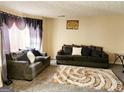 Cozy living room with plush seating, patterned rug, and natural light from large window at 1592 Smithson Ct, Lithonia, GA 30058