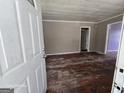 Living room with light grey walls, aged hardwood floors, and an open door at 1243 Hill Nw St, Conyers, GA 30012