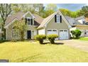 Lovely home with a two-car garage, a neat front lawn, and inviting curb appeal at 75 Prestwick Ln, Peachtree City, GA 30269