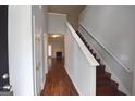 Bright hallway with hardwood floors, staircase, and a glimpse into the living room at 75 Prestwick Ln, Peachtree City, GA 30269