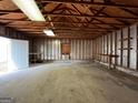 Garage with a concrete floor, exposed wooden rafters, and a white door to the outside at 1397 Iron Gate Blvd, Jonesboro, GA 30238