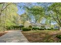 Home exterior with lush green lawn and a long driveway leading to an attached garage at 115 Bob White Trl, Fayetteville, GA 30215