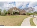 Stately brick home with well-manicured lawn, sidewalk, and mature trees creating an inviting curb appeal at 217 Brunswick Dr, Tyrone, GA 30290