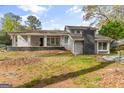 A charming home is showcased with a stone chimney and inviting porch swing on a lush green lawn at 205 Raintree Bnd, Peachtree City, GA 30269