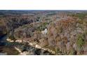Serene aerial shot of the property surrounded by lush forest and a winding river, highlighting its secluded location at 3212 Sw Woodhaven Sw Ct, Conyers, GA 30094