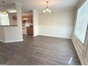Inviting dining room featuring modern flooring, classic wainscoting, and a stylish chandelier at 661 Outlook Way, South Fulton, GA 30349