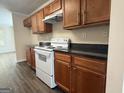 Functional kitchen equipped with white appliances, dark countertops and ample cabinet space at 661 Outlook Way, South Fulton, GA 30349