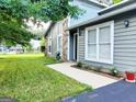 View of home exterior with white trim, green siding, stone accent wall, and a lush green lawn at 1475 Woodington Cir, Lawrenceville, GA 30044