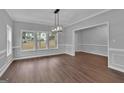 Bright dining room with hardwood floors, modern light fixture and large windows at 250 Stonecreek Pkwy, Covington, GA 30016