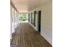 Long covered front porch with stained wood floor, white columns, and an open view at 25 Dove Pt, Covington, GA 30016