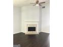 Bright living room featuring a decorative fireplace, ceiling fan and dark wood-look floors at 25 Dove Pt, Covington, GA 30016