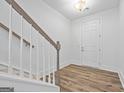 Bright foyer showcasing wood-look flooring, a staircase with white banisters, and a white front door at 1516 Parks Edge Nw Ln, Atlanta, GA 30318
