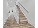 Inviting entryway featuring wood-look flooring and a staircase with carpeted steps and a stylish wooden handrail at 1516 Parks Edge Nw Ln, Atlanta, GA 30318