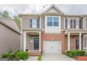 Attractive townhome with a single-car garage, brick accents, and manicured shrubs at 2705 Maple Park Pl # 29, Cumming, GA 30041