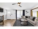 Comfortable living room with modern ceiling fan, wood flooring, and an adjacent dining area at 6490 Cainwood Dr, Atlanta, GA 30349