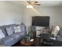 Cozy living room with plush gray sofa, decorative pillows, and a modern ceiling fan at 579 Wexwood Dr, Riverdale, GA 30274