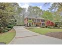 Long driveway leads to a beautiful two-story brick home, framed by lush landscaping at 285 Broadmoor Dr, Fayetteville, GA 30215