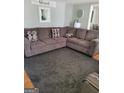 Inviting living room with a large comfortable sectional sofa and neutral gray color palette at 4365 Newton Cir, Douglasville, GA 30134