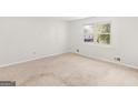 Bright, neutral bedroom with carpeted floor and a large window at 1508 Bonanza Church Rd, Jonesboro, GA 30238