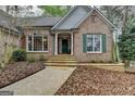 Close up of brick home's front entrance featuring a stone walkway and complementary green shutters at 3230 Riverhill Ct, Cumming, GA 30041