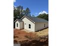 New house with a dark roof and light siding, showing the rear elevation, on a partially cleared lot at 543 Courthouse Park Dr., Temple, GA 30179