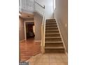 Foyer features carpeted staircase and wood-look flooring at 1132 Saint Phillips Ct # 90, Locust Grove, GA 30248