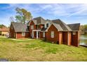 Beautiful red brick home with a large yard, well-maintained lawn, and lake view at 170 Austin Oaks Dr, Ellenwood, GA 30294