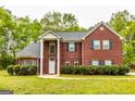 Classic brick residence with a symmetrical facade, dark shutters, and lush green landscaping at 1015 Middlebrook Dr, Mcdonough, GA 30252