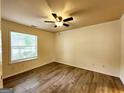 Spacious bedroom featuring modern ceiling fan, large window offering natural light and hardwood floors at 645 Crossbridge Aly, Johns Creek, GA 30022