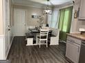 Stylish dining area with a bench and chair set, wood-look flooring and modern light fixture at 4710 Meadowlark Se Dr, Conyers, GA 30094