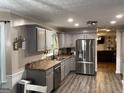 Well-lit kitchen features stainless steel appliances, gray cabinets, and wood-look flooring at 4710 Meadowlark Se Dr, Conyers, GA 30094