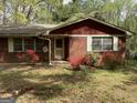 Front exterior of a quaint brick home featuring shuttered windows and a charming entrance at 8395 Rivertown Rd, Fairburn, GA 30213