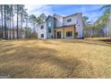 Modern farmhouse with white siding, black windows, and a spacious lawn on a sunny day at 140 Wesley Pl, Fayetteville, GA 30214