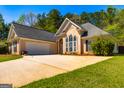 Spacious home showcasing an attached two car garage with a paved drive and well-kept lawn at 230 Hidden Brook Trl, Fayetteville, GA 30215