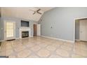 Open living room featuring a fireplace, tiled floors, high ceilings, and a ceiling fan at 230 Hidden Brook Trl, Fayetteville, GA 30215