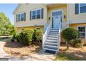 Close-up of the front entrance featuring a white door, stairs, and landscaped bushes at 3540 Owl Brow Ct, Cumming, GA 30028