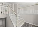 Bright interior shot showcasing a staircase with white railings and modern wood-look floors at 3540 Owl Brow Ct, Cumming, GA 30028