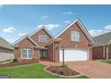 Beautiful two-story brick home featuring a brick driveway and an attached two-car garage at 1570 Woodberry Run Dr, Snellville, GA 30078