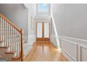 Bright foyer with hardwood floors, detailed wood trim, and a large window above the front door at 1570 Woodberry Run Dr, Snellville, GA 30078